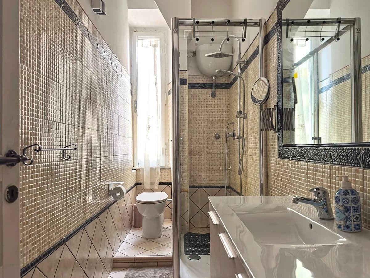 Bagno completo con doccia, lavabo e finestra