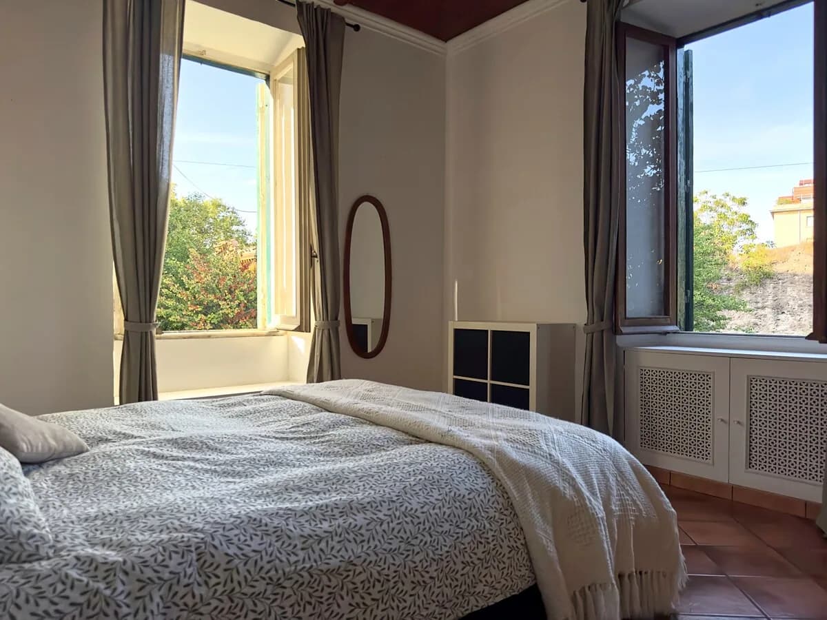 Letto matrimoniale accanto alle finestre affacciate sul verde